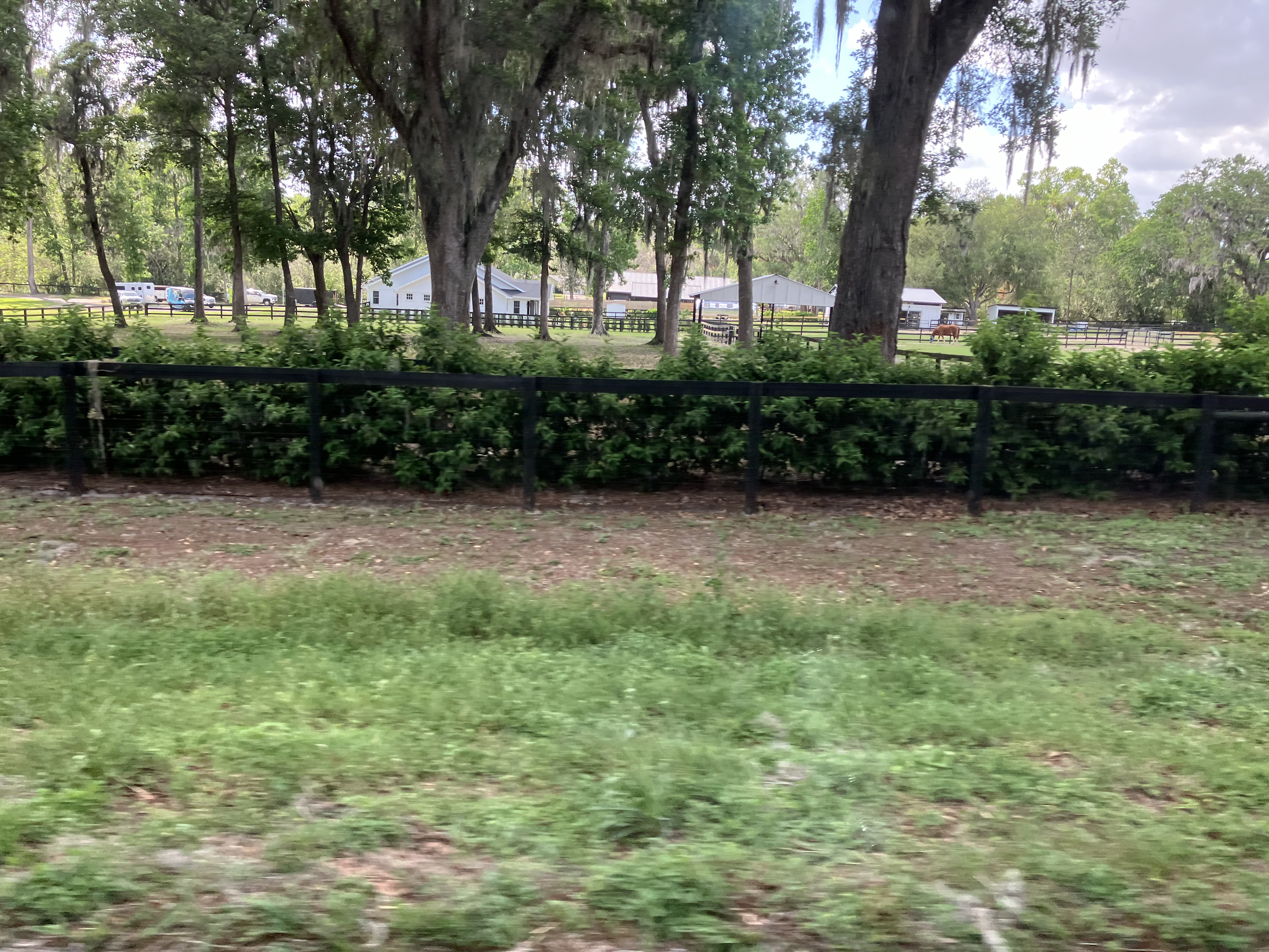 Black board fence with property and barn in background